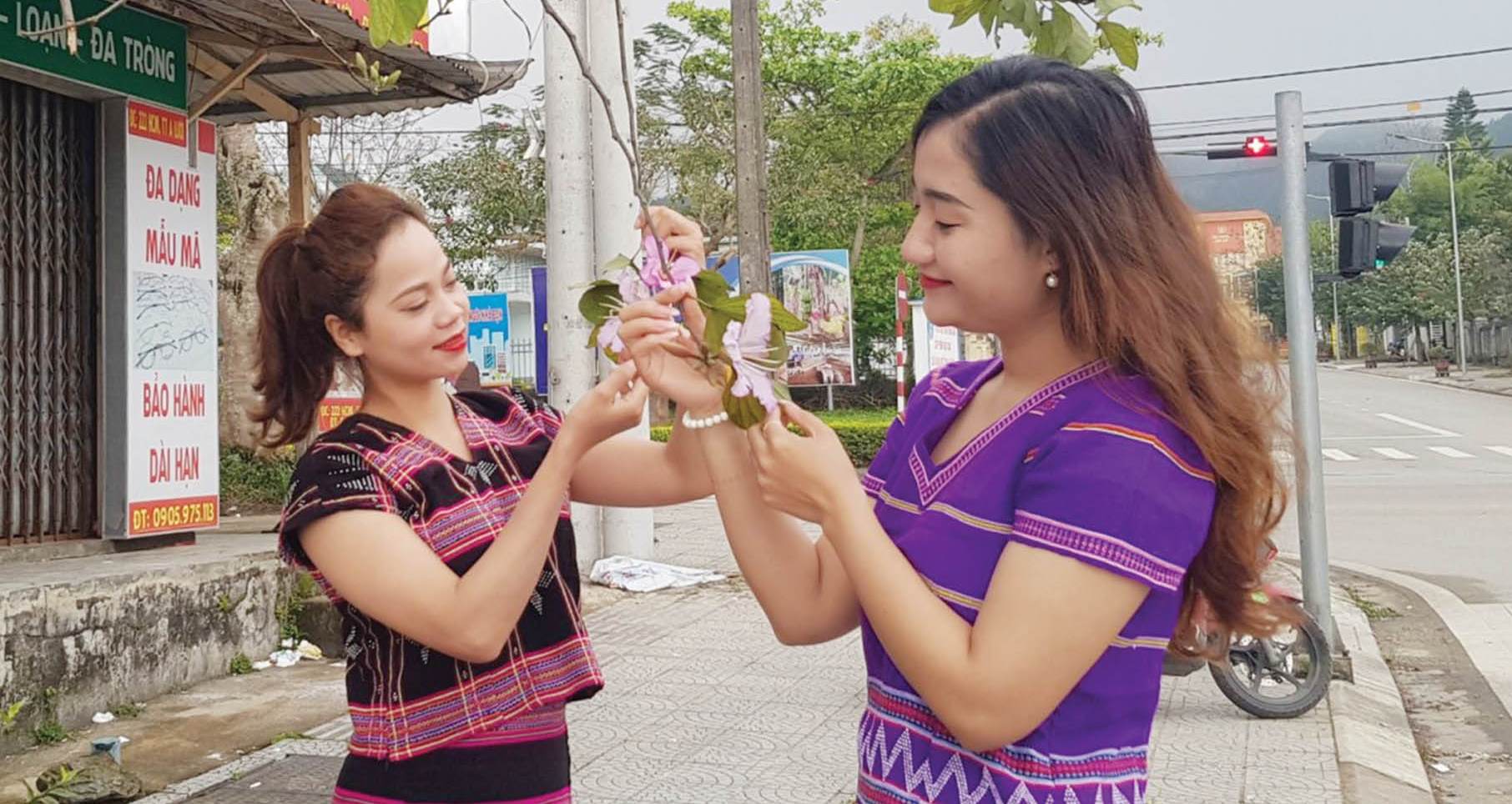 Mang trên người thổ cẩm gấm hoa