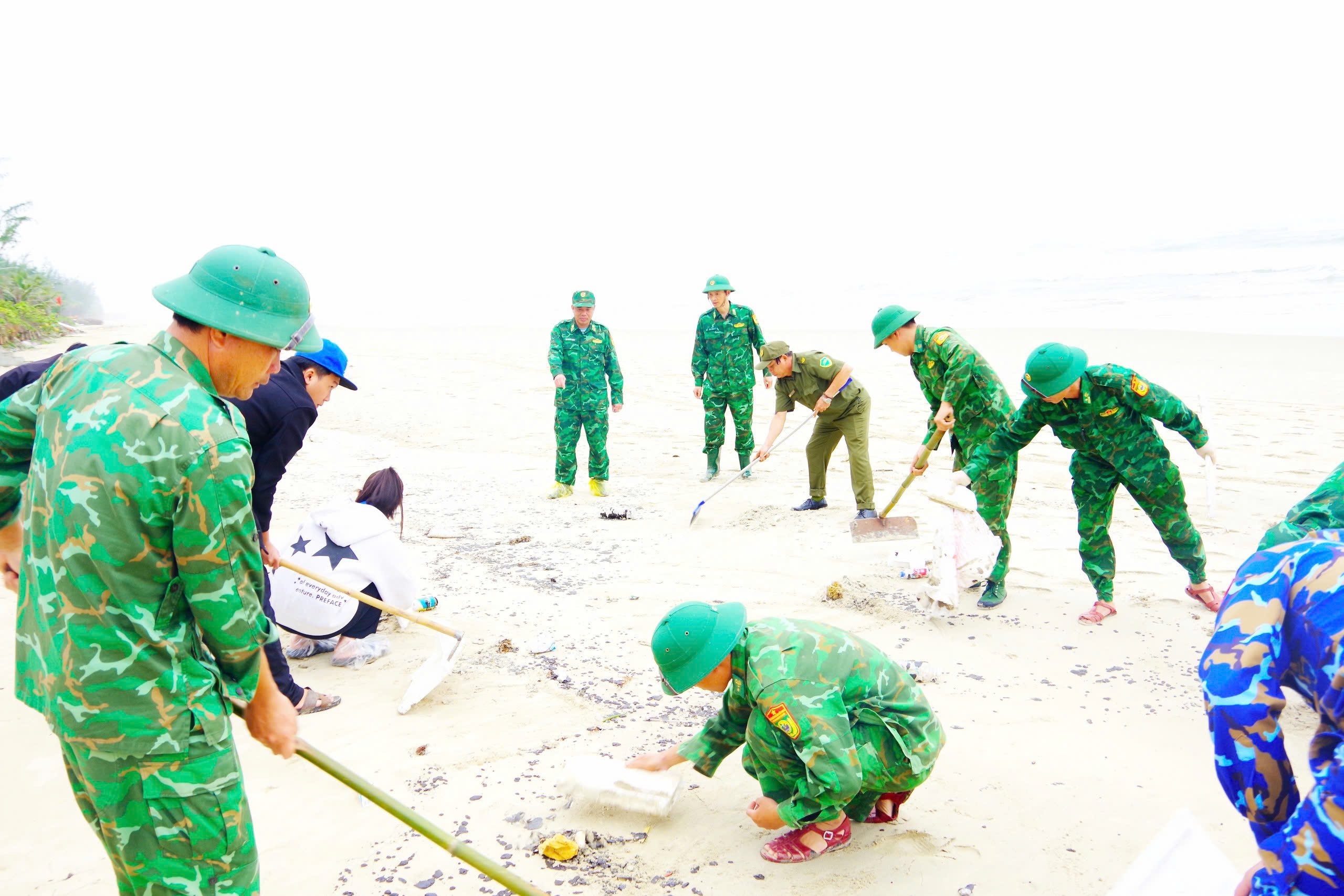 Tiếp tục thu gom dầu tràn vón cục tại khu vực bờ biển Chân Mây - Lăng Cô