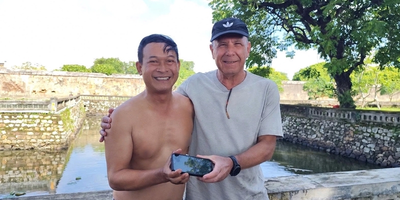 Photographer helps visitor retrieve phone dropped into pond