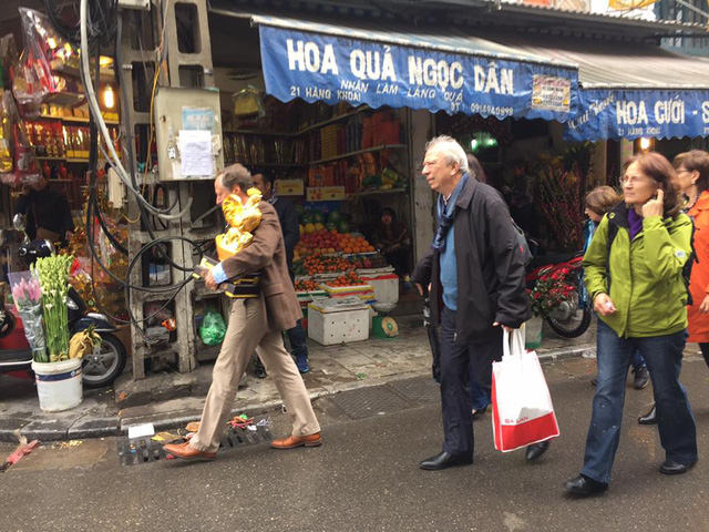 Đại sứ, Trưởng đại diện Phái đoàn Liên minh châu Âu tại Việt Nam Bruno Angelet bê một bức tượng gà mà ông sắm được trong phiên chợ Tết.