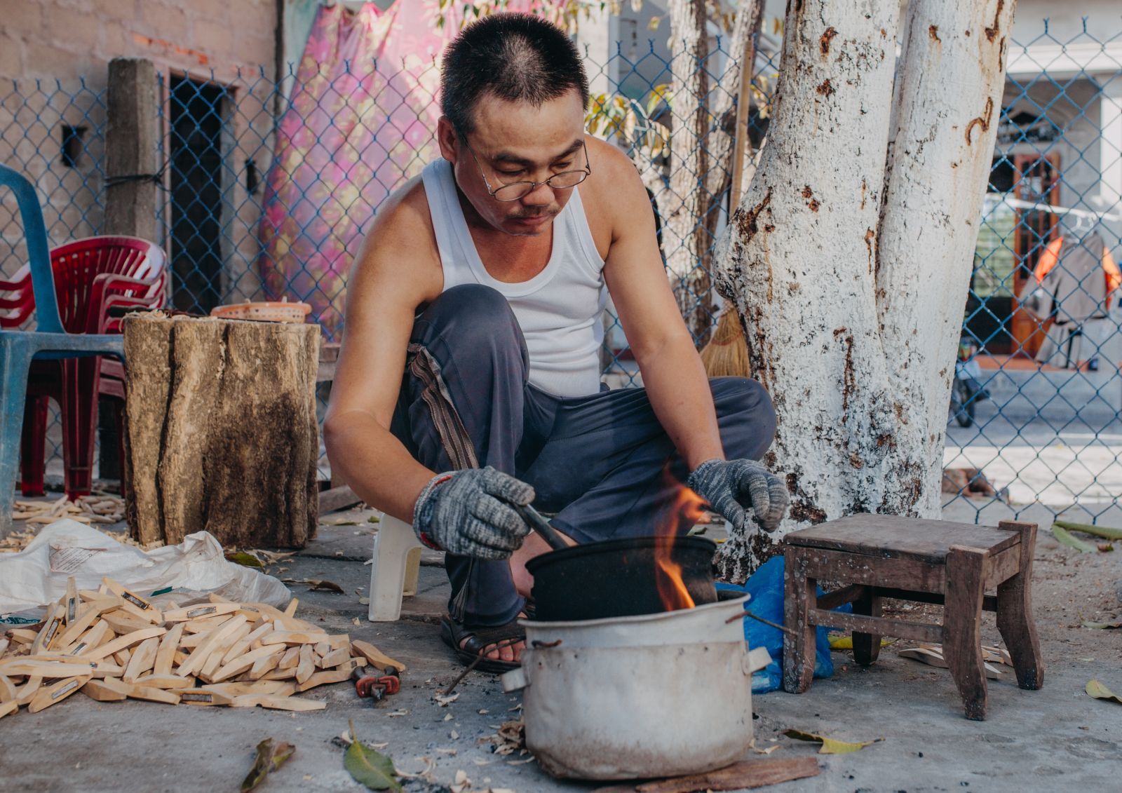 Mr. Dung preparing to pour molten lead into the wood mold. In the process of doing, it is necessary to wear protective gloves and glasses. Mr. Dung used to be hospitalized for an eye surgery to remove lead.