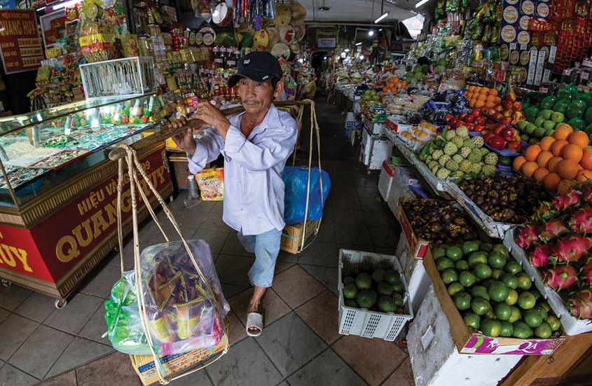 A hireling carrying goods by traditional rattan - a feature in Dong Ba market