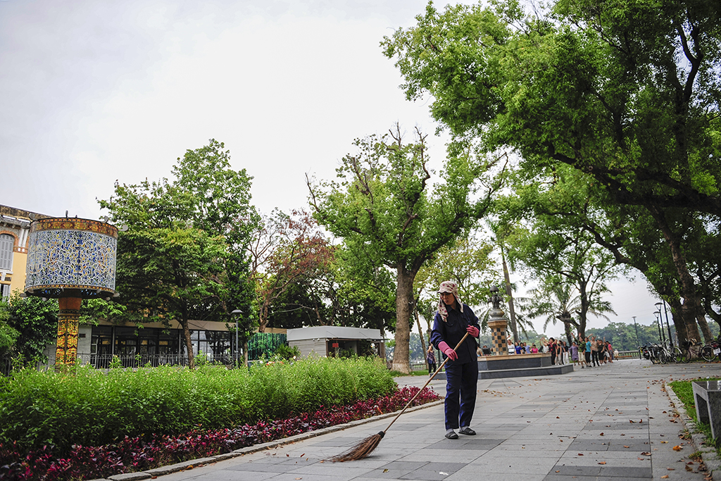 Hue Green Park Center workers sweeping leaves every early morning