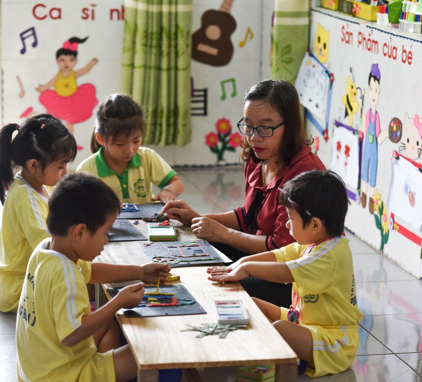 Students showing their handicrafts and being guided by the teacher