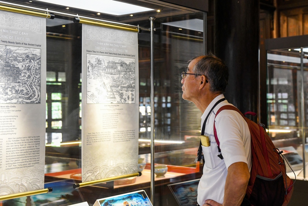 Japanese tourists attentively reading the Twenty beautiful scenes in the capital
