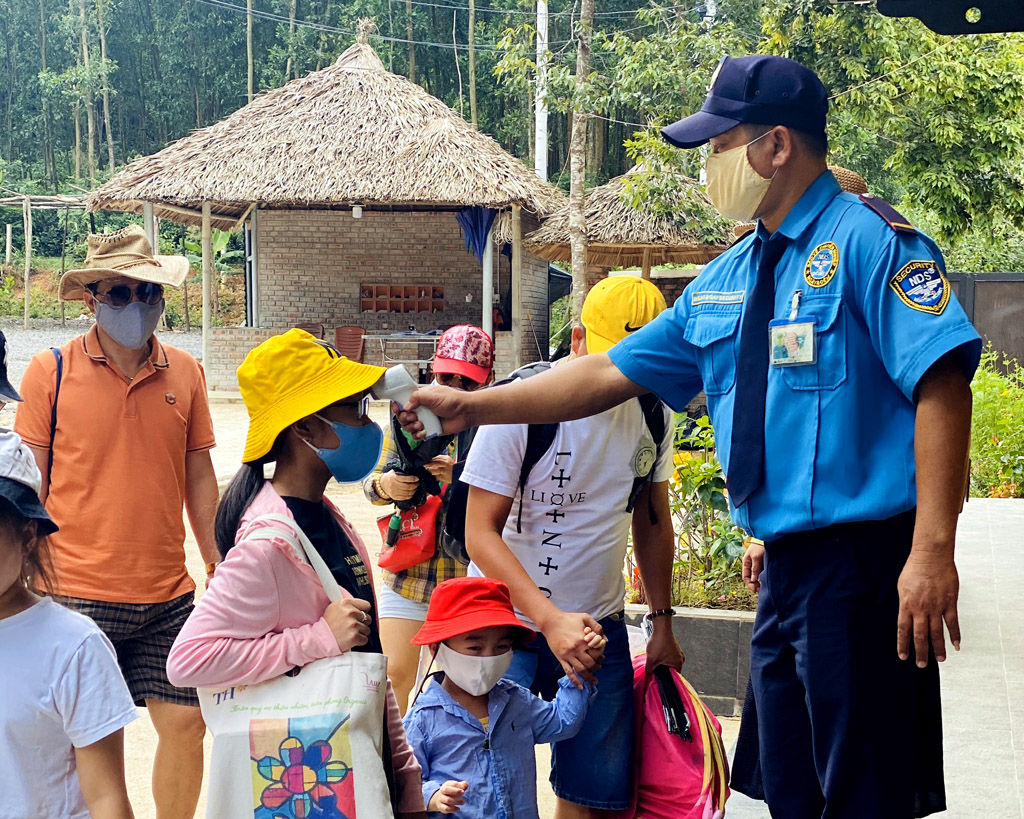 Checking body temperature of tourists before entering Bach Ma Village Spring Resort