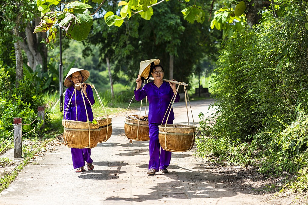 Carrying goods to the market by the bamboo pole on shoulder