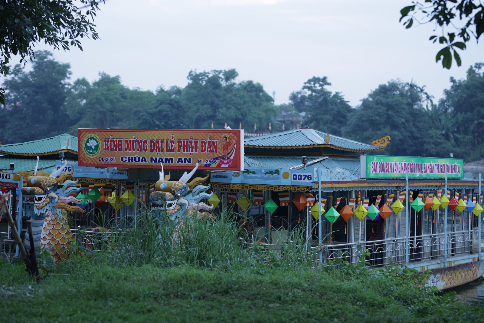 The dragon boat of Nam An pagoda is decorated with colorful lanterns, flags and flowers