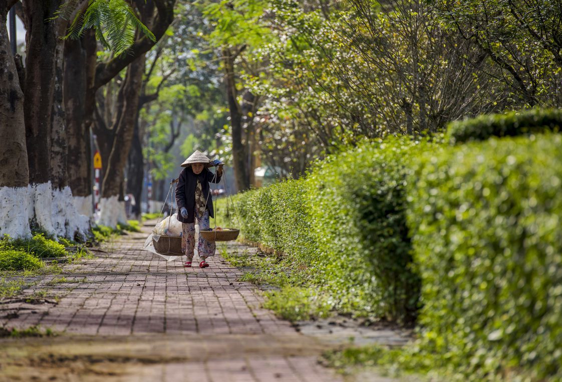 A grandma hawker walking on the street in the Autumn