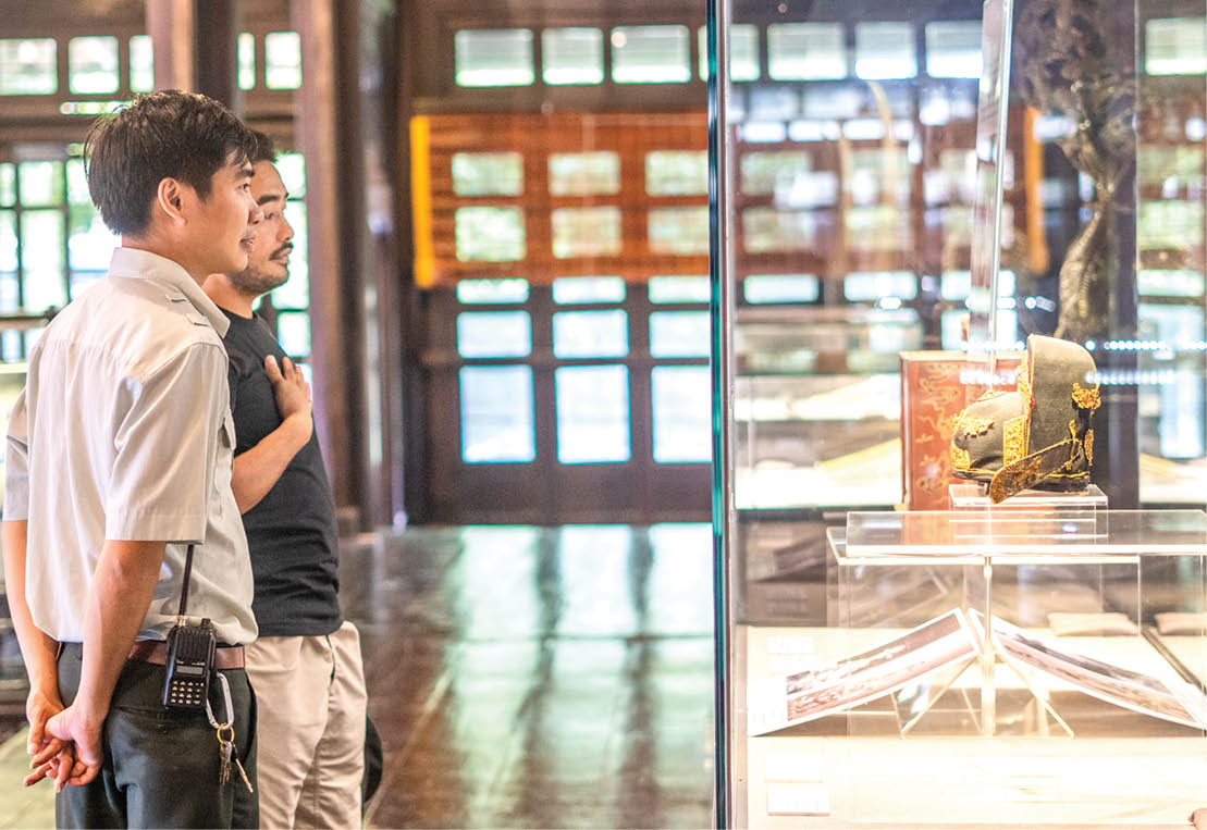 The staff at Hue Royal Antiquities Museum (far left) supporting a tourist visiting Long An Palace