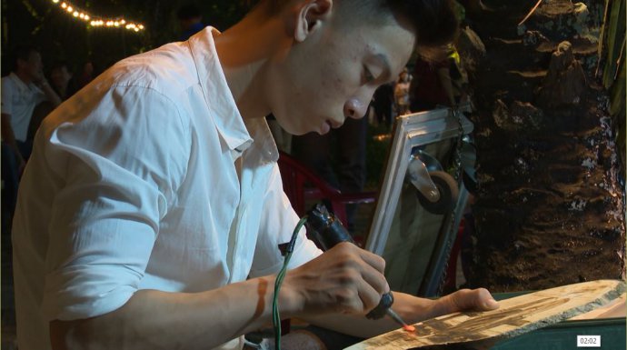 Portrait with fire pen attracts visitors on pedestrian street
