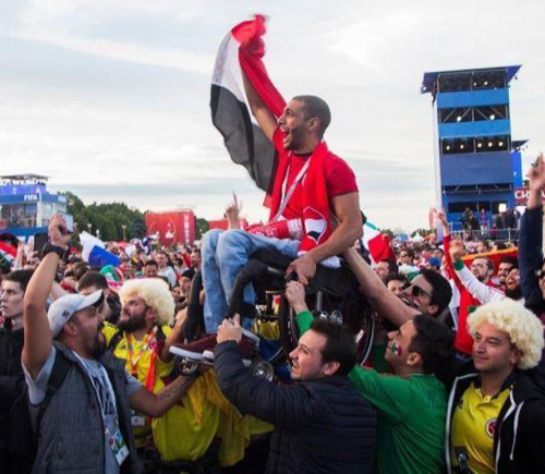 Cổ động viên nâng người ngồi xe lăn lên vai để xem World Cup