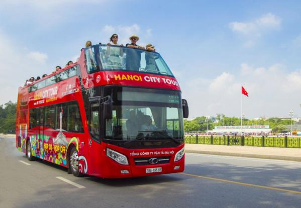 Piloting convertible double decker bus to carry tourists in Hue