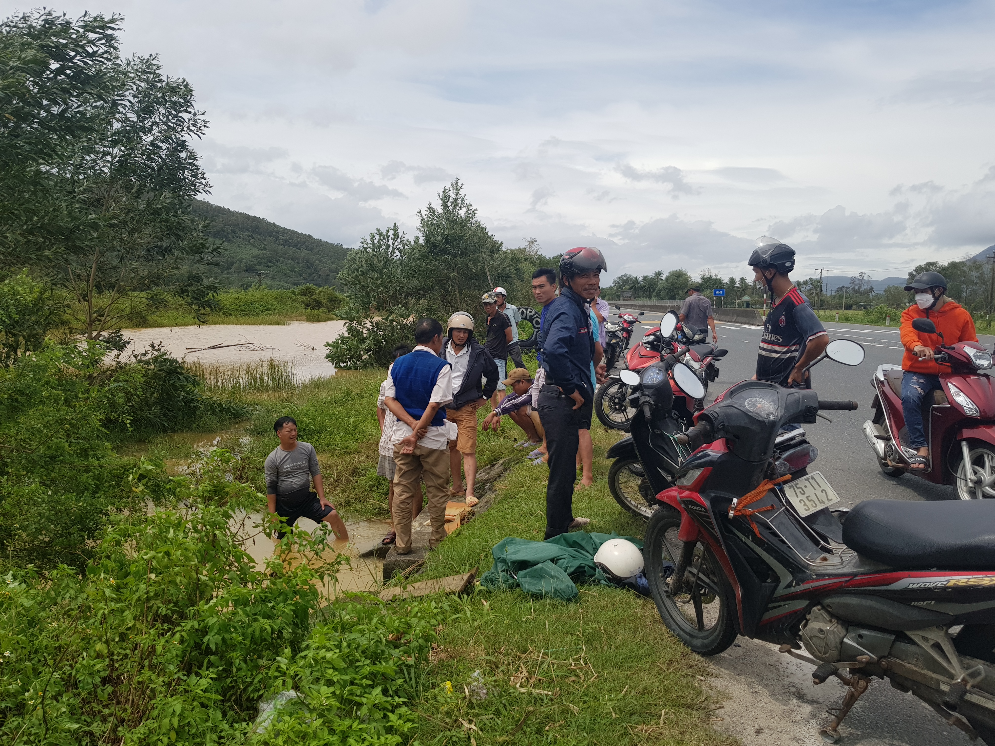 Người dân tìm cách vớt xe do lũ cuốn vào cống
